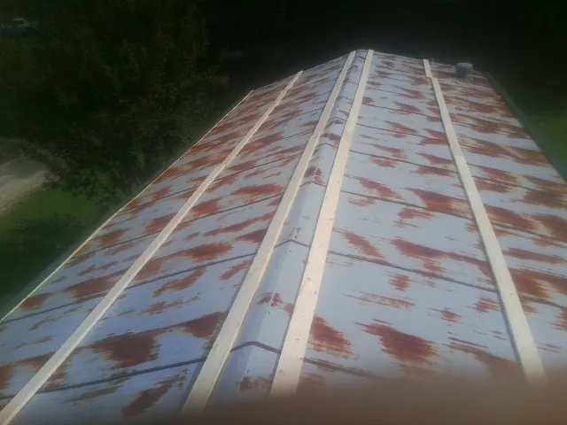 Rusted metal roof panels with new wood purlins before replacement — Storm Damage Roof Repair in Lamoni by Roofing Brothers