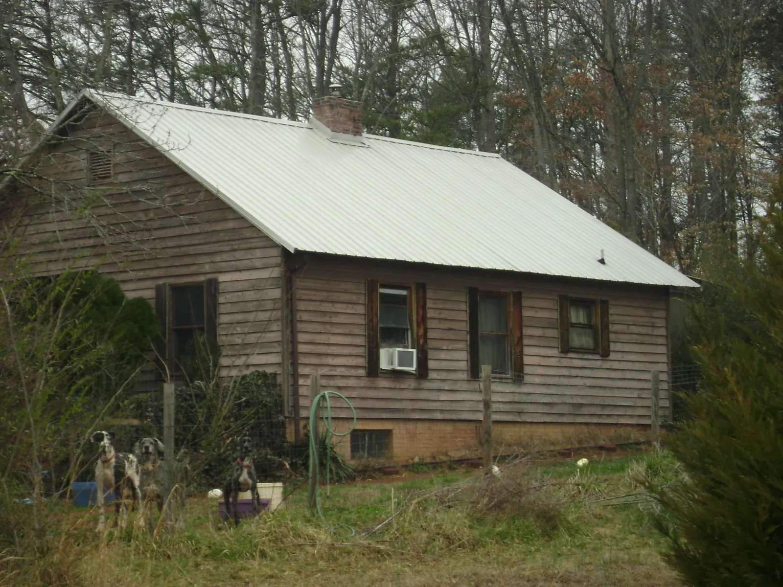 White metal roof on an old wood sided farmhouse, from a Asphalt Shingle Roof Repair job in Lamoni